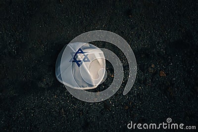 knitted kippah cap in Israeli flag style on a dark asphalt road background Stock Photo