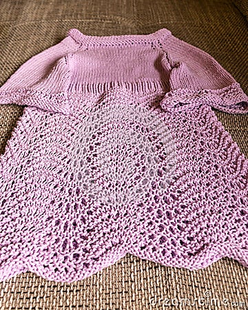 Knitted pink girls dress, handicrafts, home knit by hand, autumn handicraft time Stock Photo