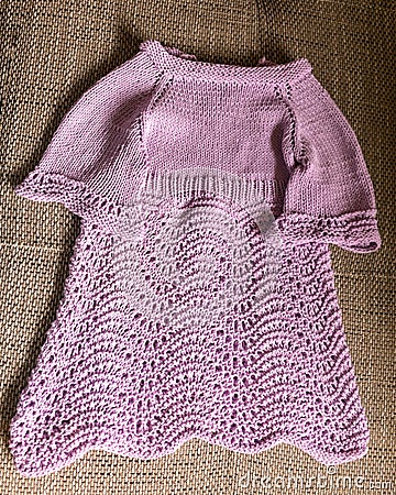 Knitted pink girls dress, handicrafts, home knit by hand, autumn handicraft time Stock Photo