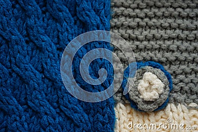 Knitted scarf pattern. Blue and gery threads. Small knitted flower on a scarf Stock Photo