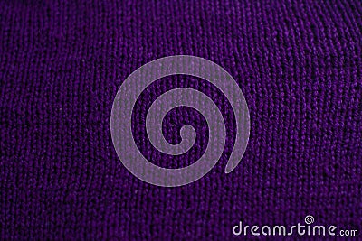 Knitted sweater with small braid, plain purple background Stock Photo