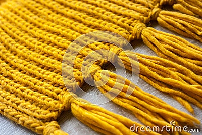 Knitted yellow scarf texture on wooden background Stock Photo