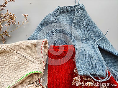 Knitter`s table with unfinished baby sweaters Stock Photo