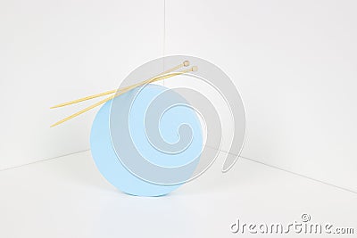 Knitting background. Round blue product display presentation podium with wooden knitting needles on white background Stock Photo