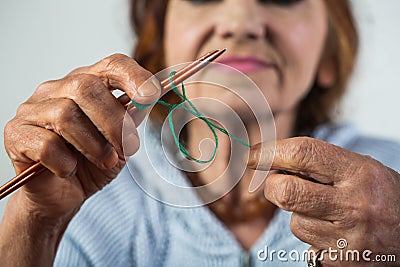 Knitting. Elegant elderly woman holding needle and wool in hand and do knitting during her leisure. Seniour lady on Stock Photo