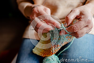 Knitting a scarf with colorful melange threads Stock Photo