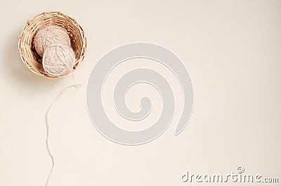 Knitting threads in a wicker basket. Beige background. Copy space. Stock Photo