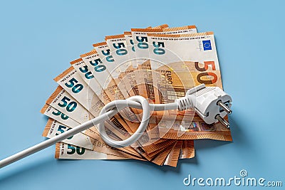 Knotted power cable with electric plug on fan shaped 50 euro banknotes over blue background. Soaring of electricity prices in Stock Photo