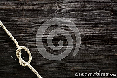 Knotted rope on dark wood Stock Photo