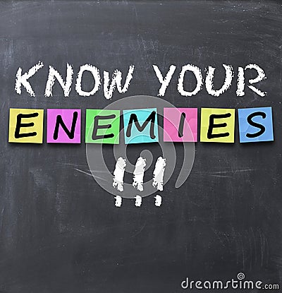 Know your enemies text on a blackboard with chalk and stickers Stock Photo