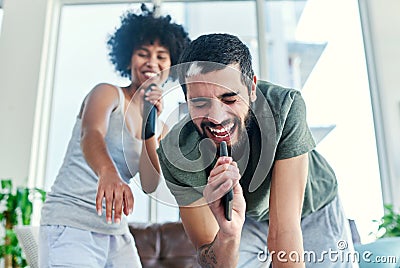 He knows that I always have his back. Cropped shot of a couple having a sing along at home. Stock Photo