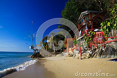 KO CHANG, THAILAND - DECEMBER 7. 2018: View on white sand beach with green trees and colorful wood houses Editorial Stock Photo