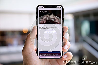 Man hand holding iPhone X with Apple Pay on the screen Editorial Stock Photo