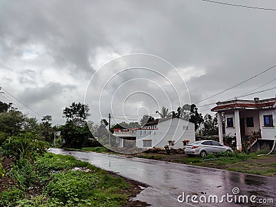 Stock photo of white painted bungalow with red color tiles on rooftop in wild countryside.vehicles parked outside of the bungalow Editorial Stock Photo