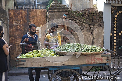 Local Indian vendor selling fresh assorted green vegetables in the van during lock down period in Editorial Stock Photo
