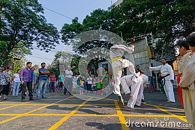 KOLKATA, WEST BENGAL, INDIA - MARCH 21ST 2015 : Young boy in white dress jumping off ground to past two fellow boys over, karate Editorial Stock Photo
