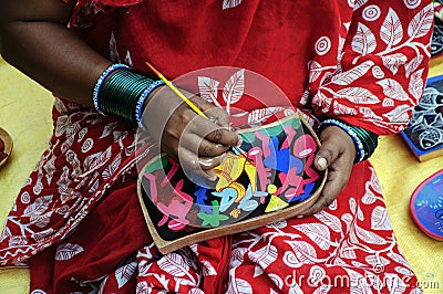 A woman artist painted on a earthen pot in a fair. Editorial Stock Photo