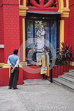 A young lady was busy in praying in front of the Statue of Mother Teresa. Editorial Stock Photo