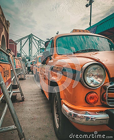 Kolkata, West Bengal: Outside Howrah Railway Station. Taxi line up for picking passengers. Howrah Bridge in background Editorial Stock Photo