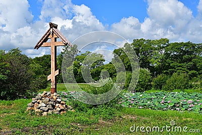 Komarov Lotus and Orthodox cross in the village of Novogordeevka. Anuchinsky district, Primorsky Krai Stock Photo