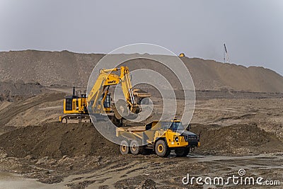 A Komatsu PC1250 excavator loads ore into a Komatsu HM400 dump truck. Editorial Stock Photo