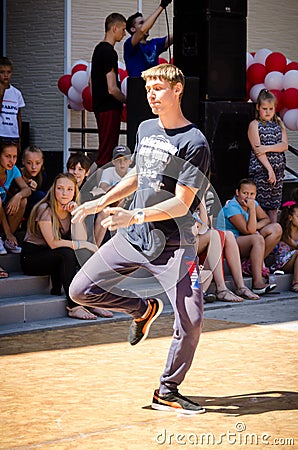 Komsomolsk-on-Amur, Russia, August 1, 2015. a boy dancing a break dance in the square with spectators Editorial Stock Photo