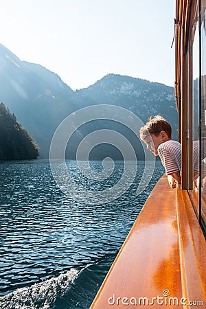 Konigssee lake, Bavaria - August 19, 2018: Unknown boy looking at green water of Konigssee, known as Germany deepest and Editorial Stock Photo