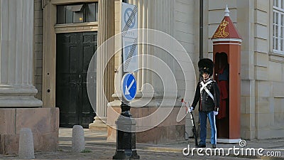 Kopenhagen, Dänemark - Oktober 2017: Soldat des königlichen Schutzes am Amalienborg-Palast, nahe rotem Wachekasten stock footage Kopenhagen, Dänemark - Oktober 2017: Soldat des königlichen Schutzes am Amalienborg-Palast, nahe rotem Wachekasten stock footage