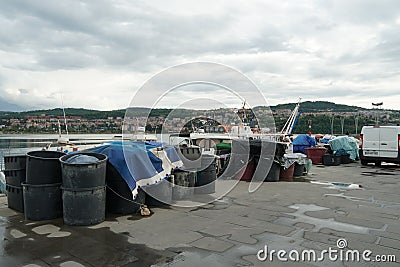 Black plastic buckets and boxes filled with fishing nets ready to load in boats moored in fishing port in Koper, Slovenia. Editorial Stock Photo