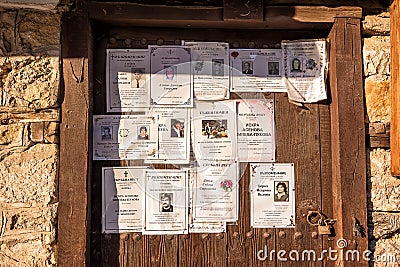 Funeral announcements posted on an old wooden door in Koprivshtitsa, Bulgaria Editorial Stock Photo