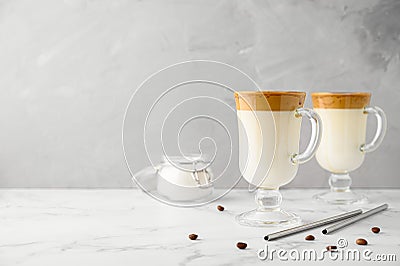 Korean Dalgona coffee in tall glass mugs. Trendy refreshment creamy whipped iced coffee. Light gray concrete background. Stock Photo