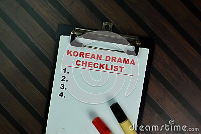 Korean Drama Checklist write on a paperwork and supported by additional services isolated on Wooden Table Stock Photo