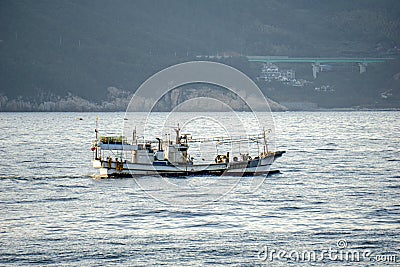 Korean fishing boat sails pass shore line in the internal waters territory Stock Photo