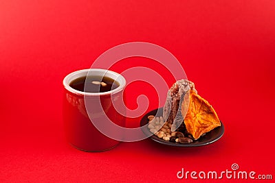 Korean fruit punch-Sujeonggwa on a red background. It is made from dried persimmons with pine nuts Stock Photo