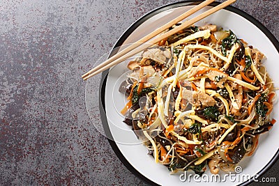 Korean Japchae Stir-fried glass noodles and vegetables closeup on the plate. Horizontal top view Stock Photo