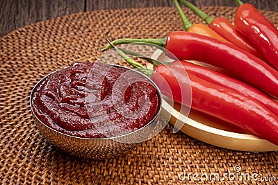 Korean pepper paste and red pepper in wooden plate, Gochujang Korean traditional Chili paste on a wooden table background. Stock Photo