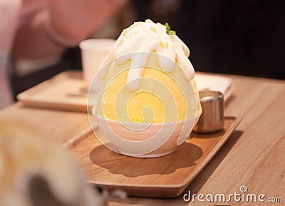 Korean shaved ice or snow cone bingsu, bingsoo dessert with chopped fresh tropical mango fruit, condensed milk, fruit syrup Stock Photo