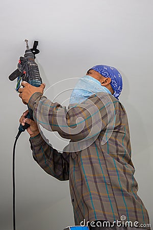 Electrician man drilling hole at ceiling for installing a new lamp for a new house Editorial Stock Photo