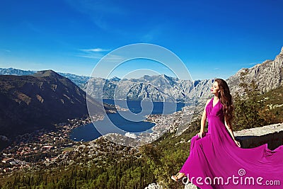 Kotor bay. Montenegro. Romantic Woman in blowing dress above Lan Stock Photo