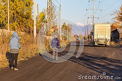 Poor wooden buildings, people and truck on the road, Kozyriewsk, Russia. Editorial Stock Photo