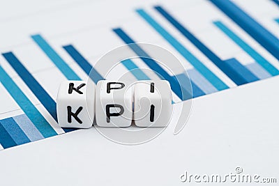 KPI, Key Performance Indicator concept, small cube block with alphabets building the word KPI on yearly chart and graph reports Stock Photo