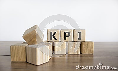 KPI symbol. Concept word `KPI - key perfomance indicator` on cubes on a beautiful wooden table, white background. Business and K Stock Photo