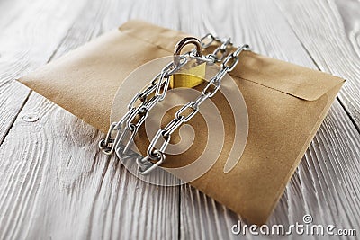 Kraft envelopes with letters and padlock, chain on old white wooden background. Protection of your post, PC mailing. Blanks for th Stock Photo