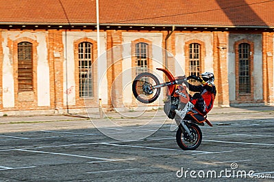 Kragujevac, Serbia - July 18, 2016: Willy motorcycle stunt. Extreme biker ride motocycle on one wheel in Stara Livnica, old factor Editorial Stock Photo