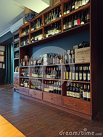 Krakow, Poland: A huge wooden shelf of vintage bottles of wine. Interior of an Italian restaurant Editorial Stock Photo