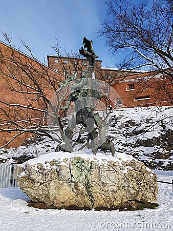 KRAKOW, POLAND, 2021 - Artistic sculpture of the legendary Wawel Dragon breathing fire at the foot of Wawel Castle. Editorial Stock Photo