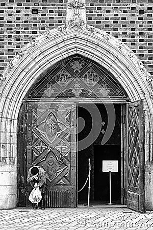 Beggar in front open doors in church Editorial Stock Photo