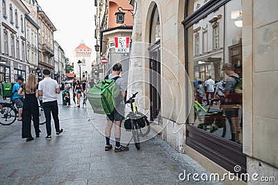 Krakow, Poland - 25 August 2022: An unidentified Uber bike courier on the street in Krakow, Poland. Delivery of food Editorial Stock Photo