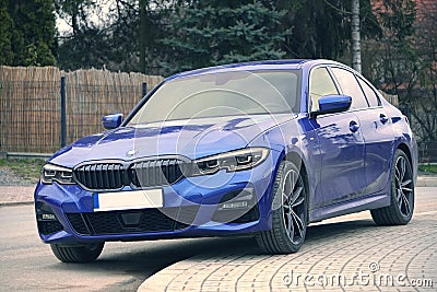 Krakow, Poland 22.03.2020: Blue car BMW 3 G20 luxury German sedan, parking in city park. Detail front view of cars. A car parked Editorial Stock Photo