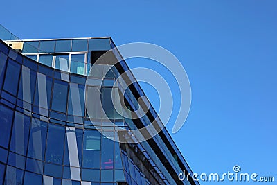 KRAKOW, POLAND, 2021 - Corner fragment of office building facade made of toned glass and steel constructions under blue sky. Editorial Stock Photo